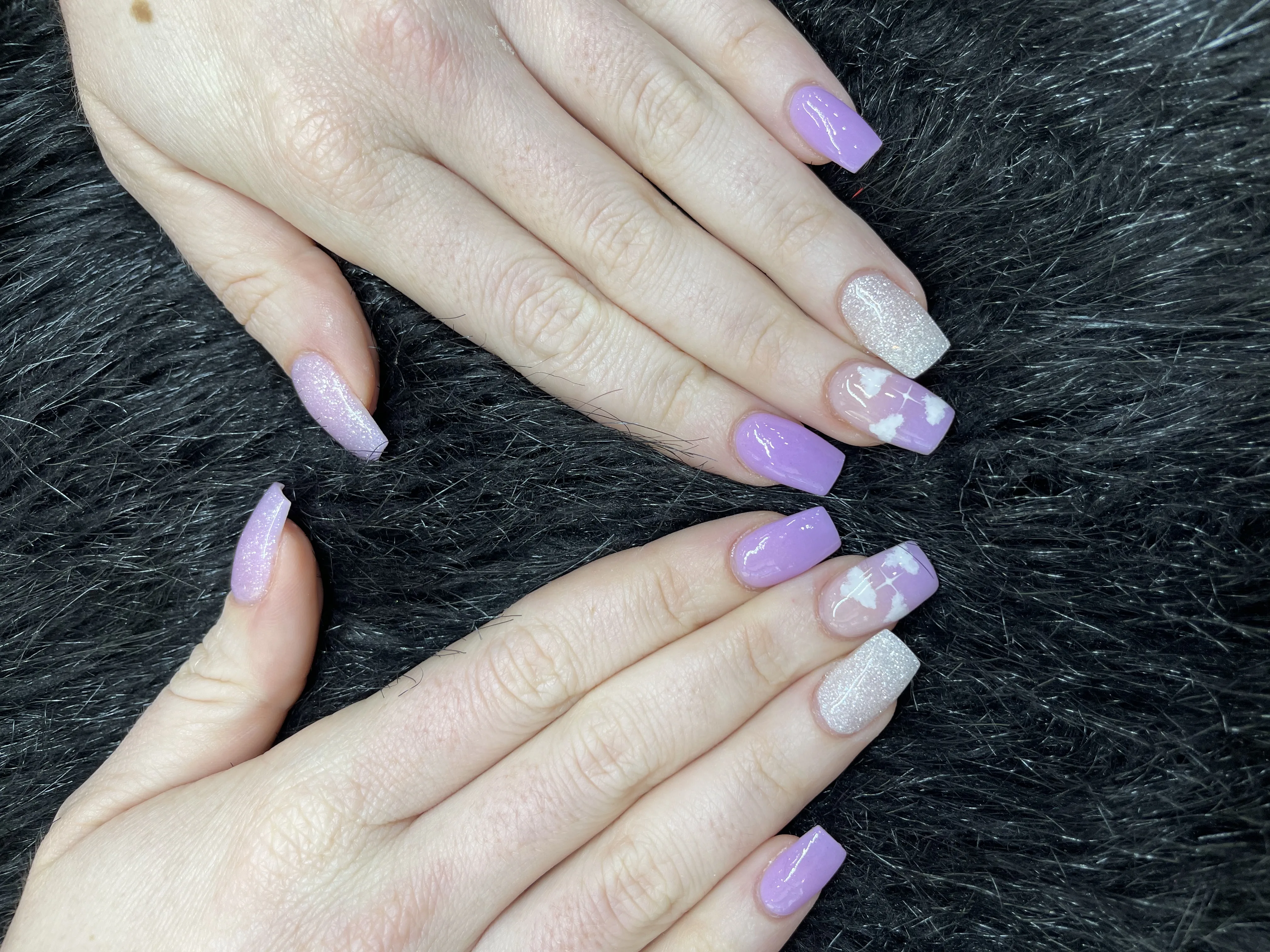 Lilac and iridescent-glitter cloud-art long coffin acrylics on black faux-fur